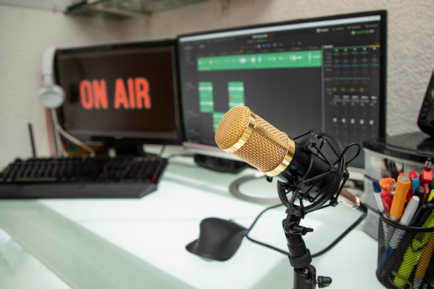 Foto microfono professionale sul tavolo di lavoro per trasmissioni podcast o discorsi radiofonici