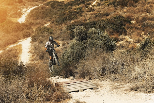 산에서 자전거를 타고 내리막길을 타는 동안 점프하는 전문 MTB 자전거 라이더