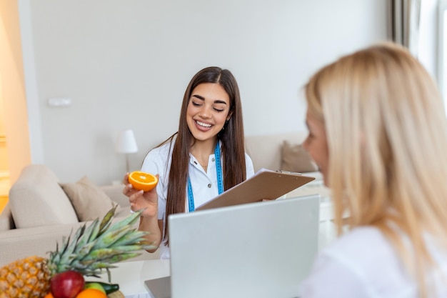 Nutrizionista professionista che incontra un paziente in ufficio e frutti sani con metro a nastro