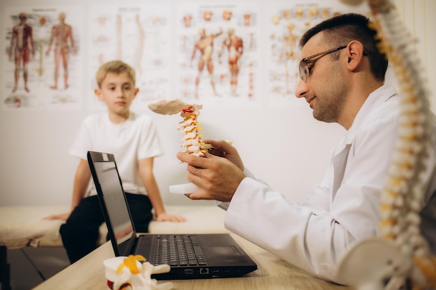 Professional orthopedist examining little patients in clinic