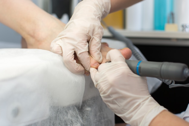 Professional pedicure master making pedicure in salon