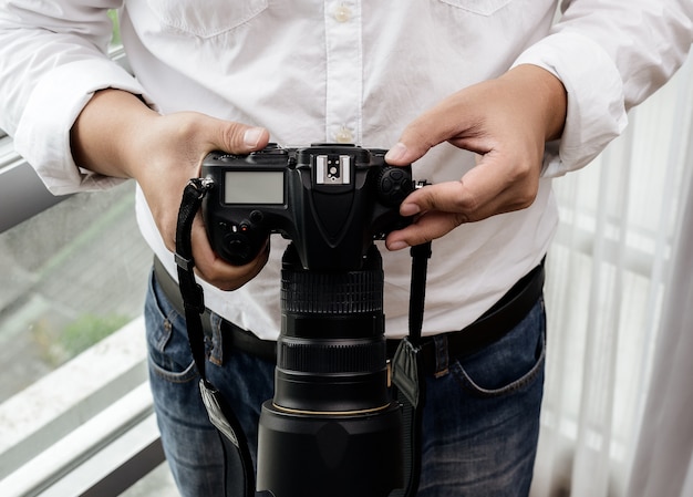 Фото Профессиональный фотограф настраивает камеру перед съемкой