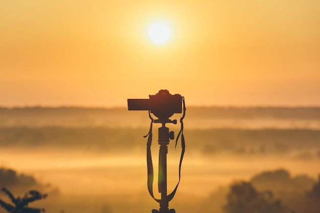 Photo a professional photographers camera on a tripod looks at the sunrise