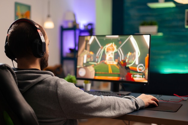 Professional player with headset playing videogame with modern graphics for shooter competition. Online streaming cyber performing during gaming tournament using technology network wireless
