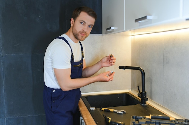 professional plumber fixing water tap in kitchen