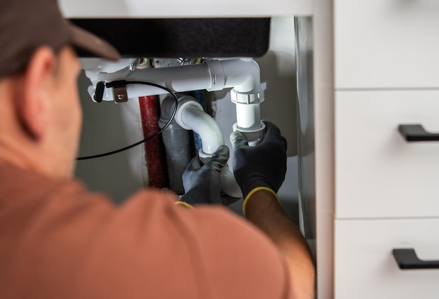 Foto idraulico professionista che installa il nuovo drenaggio del lavandino