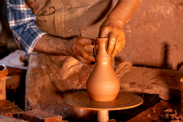 Professional potter making bowl in pottery workshop, studio.