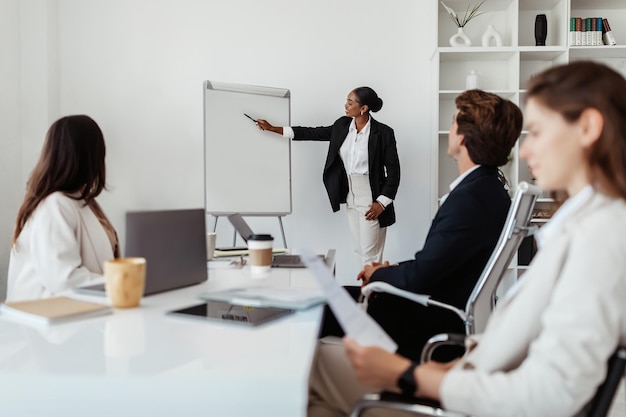 Professional presentation black businesswoman giving speech at corporate meeting pointing at