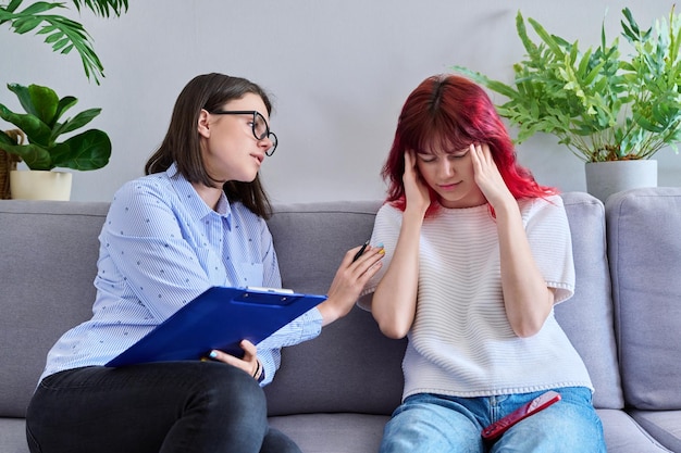 Professional psychologist working with teenage student girl