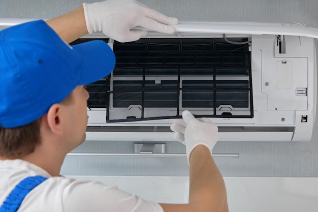 Professional repairman of air conditioning equipment replaces filter elements