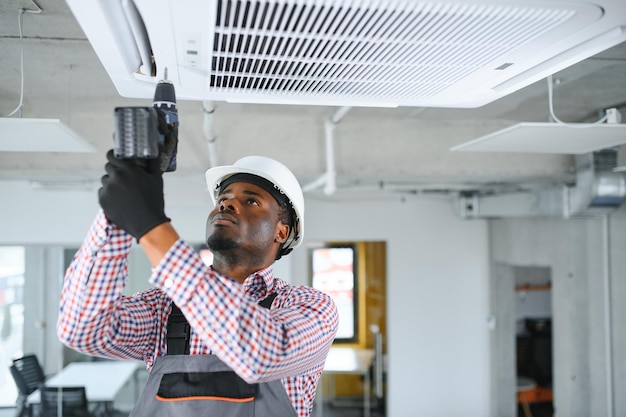 Photo professional repairman installing air conditioner in a room