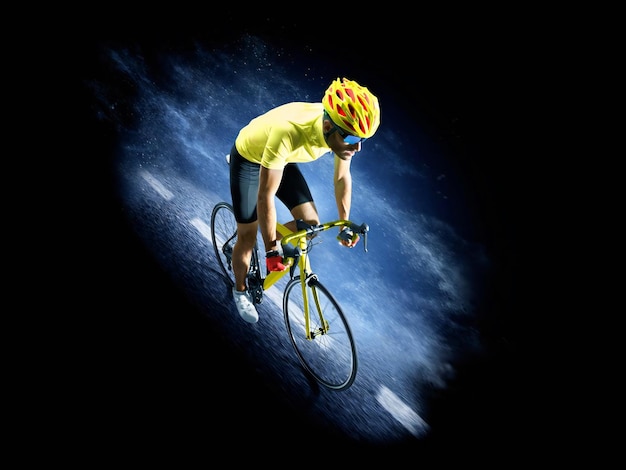 Professional road bicycle racer in action isoated on the black background