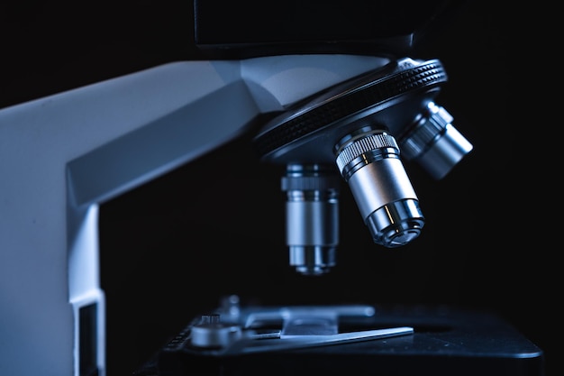 Микроскоп профессионального научного оборудования для ученого-медика, использующего в биотехнологической лаборатории исследования биологии или химии и медицинских технологий с микробиологическим экспериментом