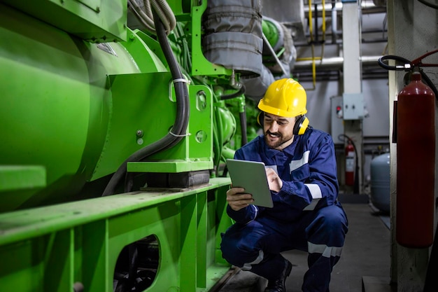 Professional serviceman engineer checking parameters of gas generator and voltage in power plant