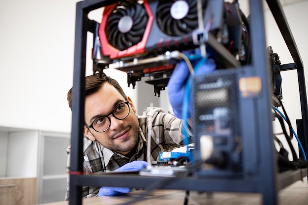 Professional serviceman repairing graphics card and servicing bitcoin mining rig