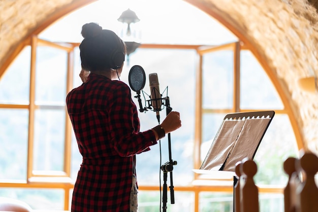 Professional singer woman recording a song in a studio