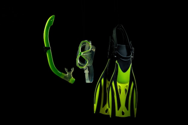 Photo professional sport equipment isolated on black studio background. swimming flippers and mask.