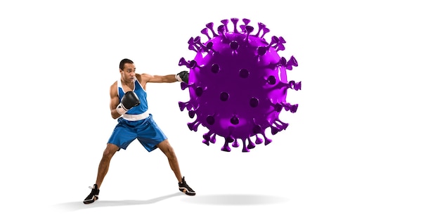 Sportivo professionista che calcia, prende a pugni il modello di coronavirus: combatti la malattia, sii forte, al sicuro. raggiungimento obiettivo, sport, stile di vita sano, trattamento della polmonite covid-19. competizione, campionato.