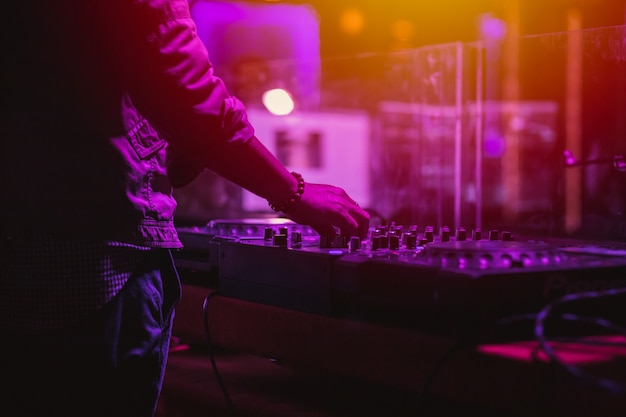 Photo professional stage sound mixer closeup at sound engineer hand using audio mix slider working during concert performance