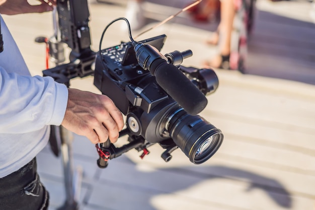 Photo professional steadicam operator uses a 3axis camera stabilizer system on a commercial production set