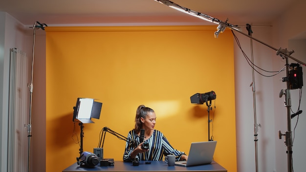 Professional studio set of video blogger recording new episode about camera lens. Content creator new media star influencer on social media talking video photo equipment for online internet web show