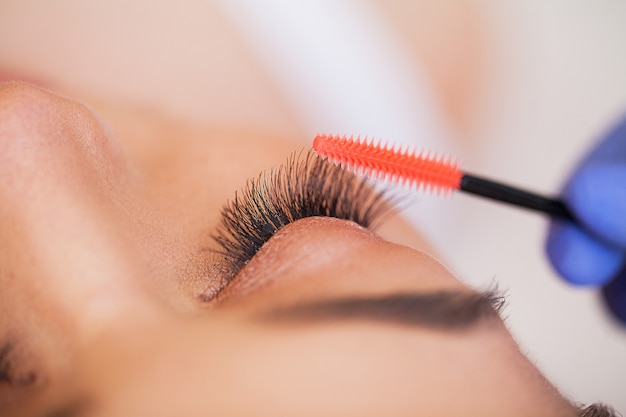 Professional stylist lengthening female lashes.