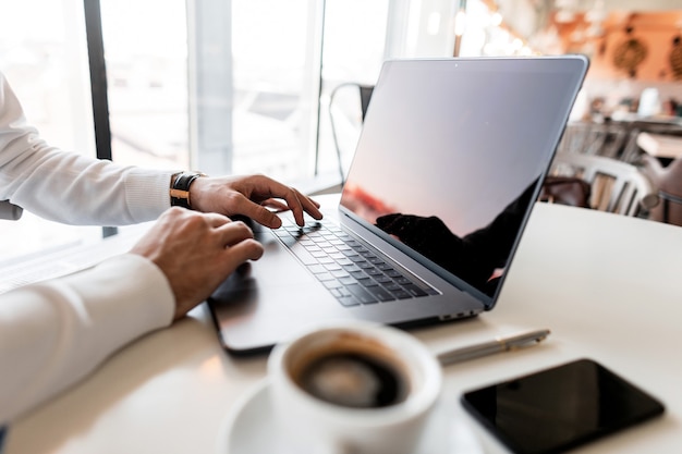 Photo professional successful business man sits in a bright office in a working day and works at a laptop