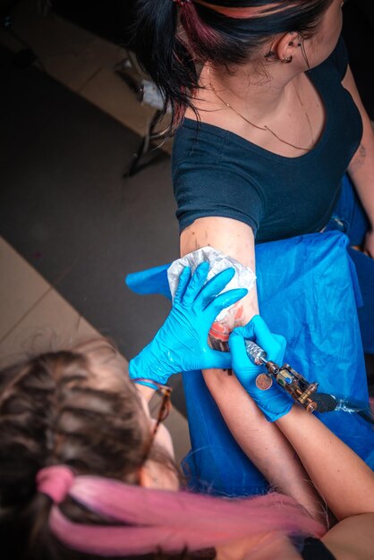 Il tatuatore professionista dimostra il processo per ottenere il tatuaggio in studio di tatuaggi.