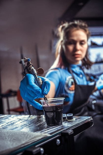 Professional tattooer makes tattoo pictures in tatoo salon.