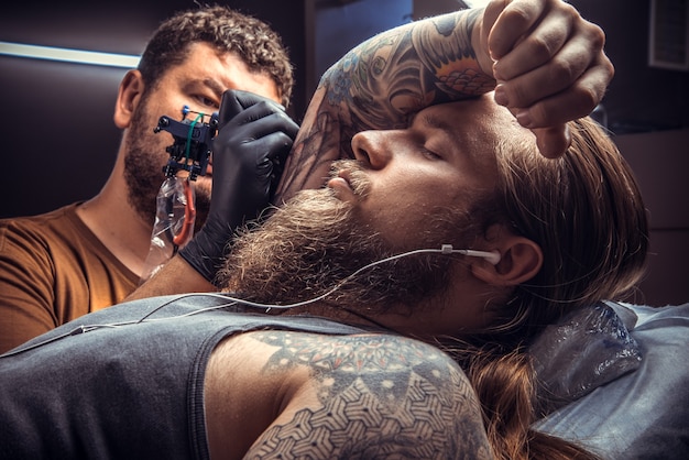 Professional tattooer posing in tattoo studio.