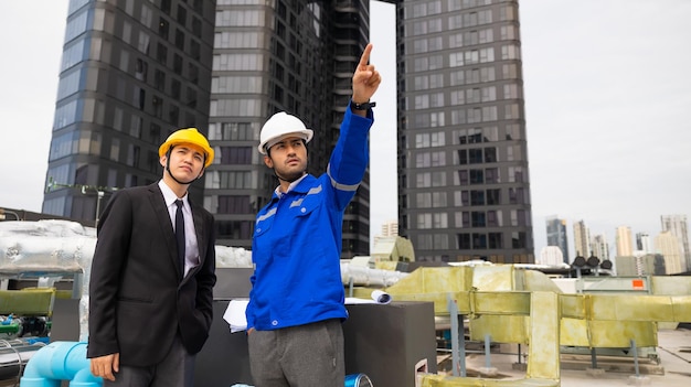 Professional team Asian business man young ceo and energy engineer plan a project to build a solar panel for the building under construction clean and green alternative energy concept