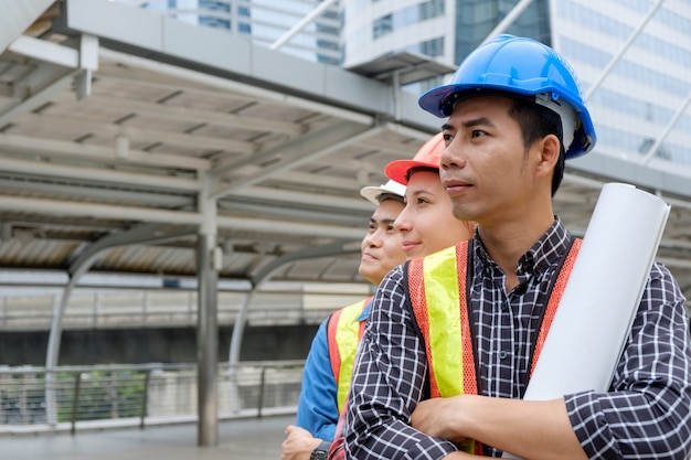 Professional team engineer standing crossed arms on skyscraper background