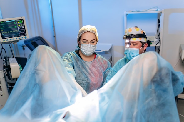 写真 病院の手術室で特別な医療機器を使用して手術を行う外科医肛門科医の専門チーム緊急手術コンセプト