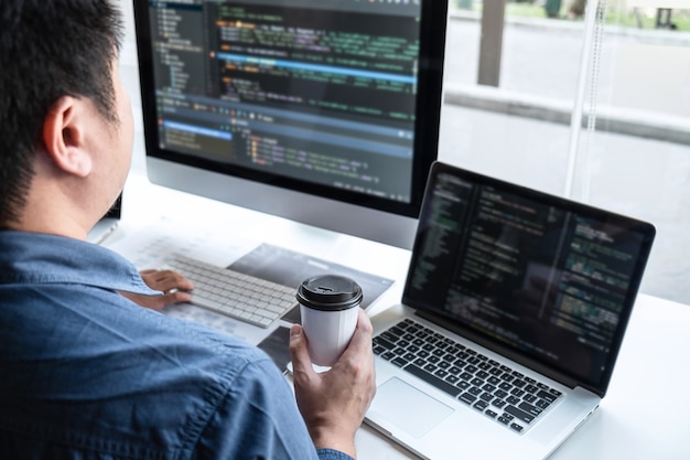 IT企業のオフィスにあるソフトウェア開発コンピューターのプロジェクトに取り組んでいるプログラマーの専門家チーム。新しいアプリケーションでコードとデータコードのWebサイトを作成し、データベーステクノロジをコーディングしています。
