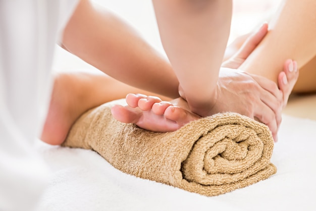 Photo professional therapist giving reflexology foot massage to a woman in spa