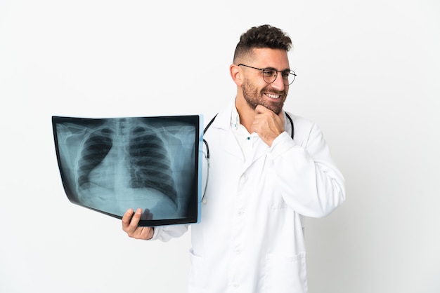 Professional traumatologist isolated on white background looking to the side and smiling