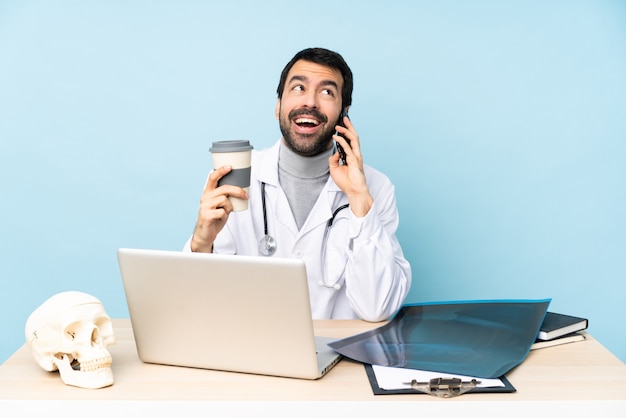 Professional traumatologist in workplace holding coffee to take away and a mobile