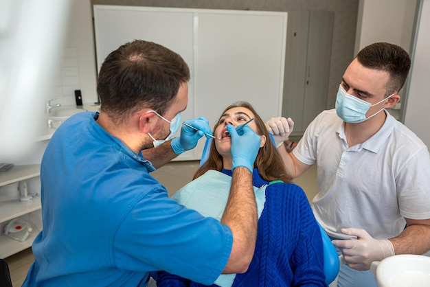 Professional treating female patient teeth at dental clinic health care