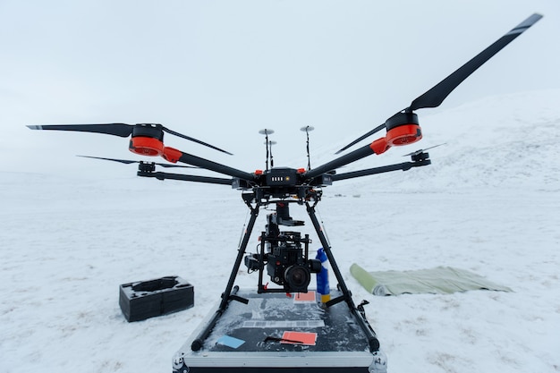 Professional video camera and modern drone in winter cold field