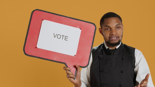Professional waiter showing a message to vote on speech bubble