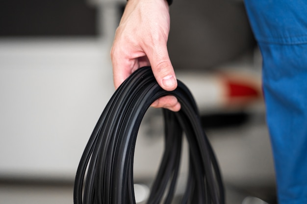 Professional window repair and installation technician holding a rubber gasket for pvc windows in his hand.