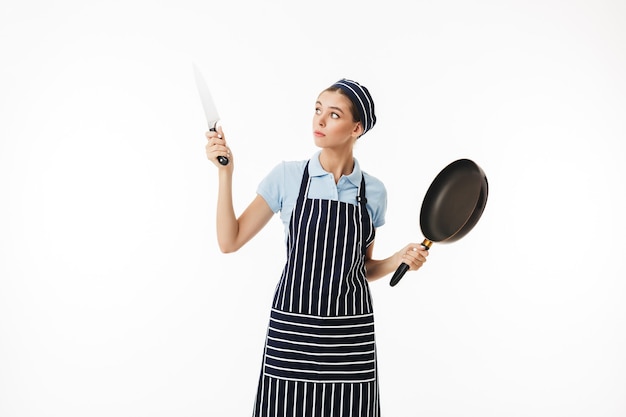 Professional woman cook in striped apron and cap thoughtfully 