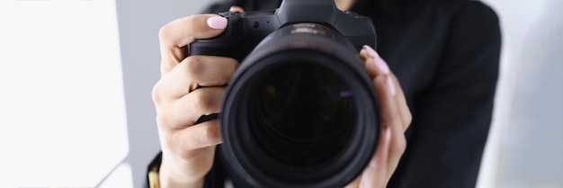 Профессиональный фотограф женщина держит последнюю модель фотоаппарата