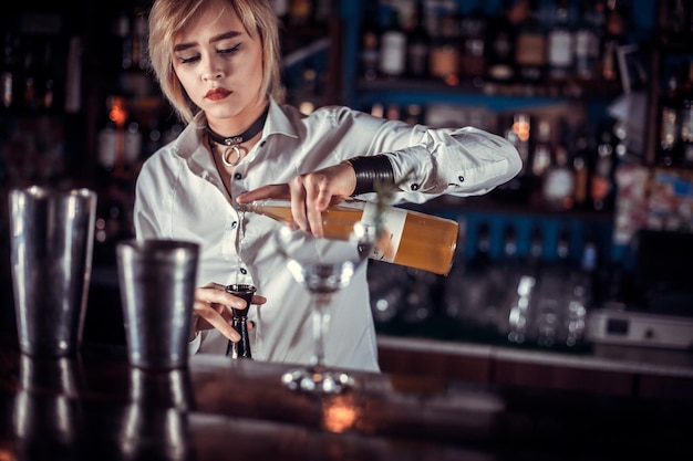 Professional woman tapster demonstrates his professional skills in pub