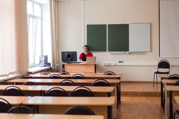 Foto insegnante professionista che lavora in un auditorium vuoto di una scuola superiore o di un college