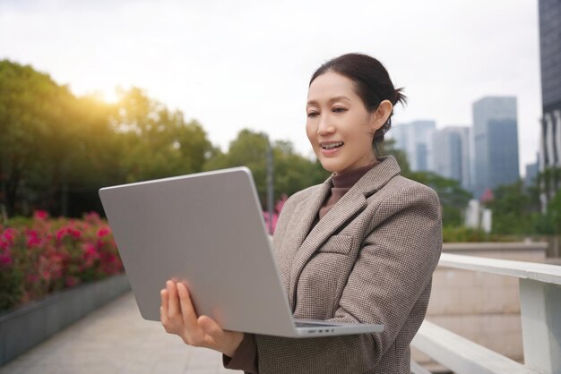 Professional Woman Using Laptop in Urban Park