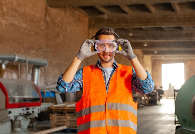 Foto falegname professionista che indossa occhiali di sicurezza in officina. concetto di falegnameria e lavorazione del legno