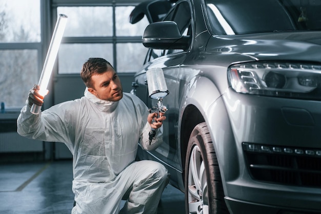 Professional worker Man in uniform is in the auto service