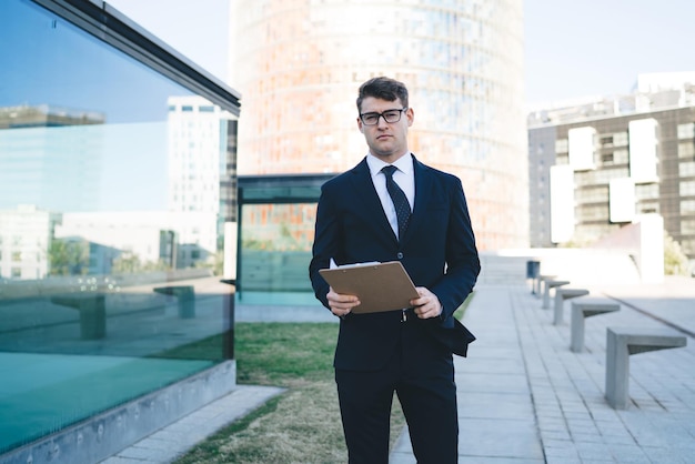 Professional worker with clipboard on street