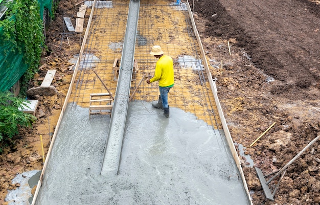 専門の労働者は、重工業の建設現場でセメントの床を作ります。
